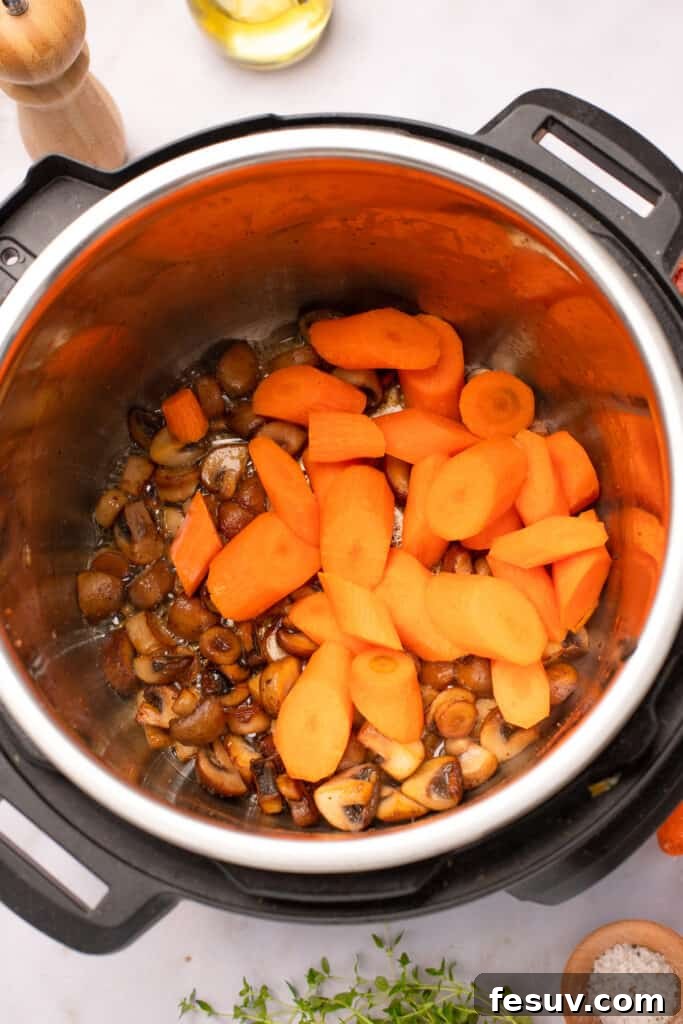 Instant Pot Coq au Vin: Classic French Flavor, Modern Speed 6 Mushrooms and carrot pieces browning in the bottom of an Instant Pot.