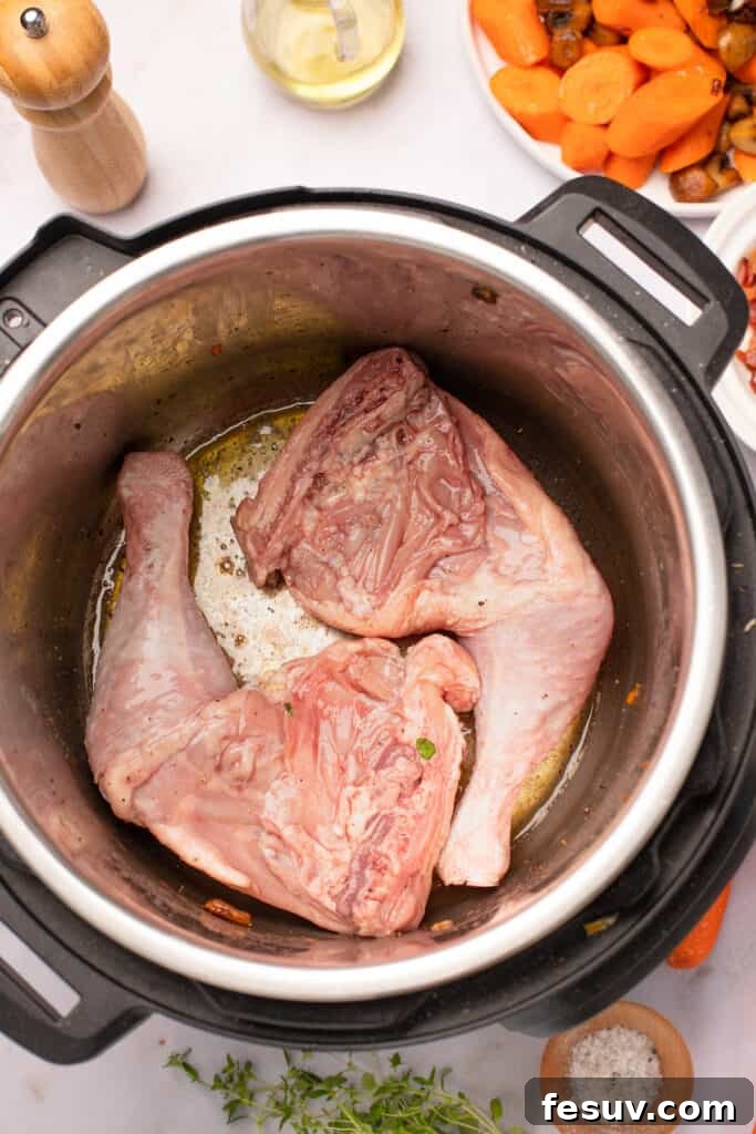 Instant Pot Coq au Vin: Classic French Flavor, Modern Speed 7 Marinated chicken legs frying in the bottom of an Instant Pot.