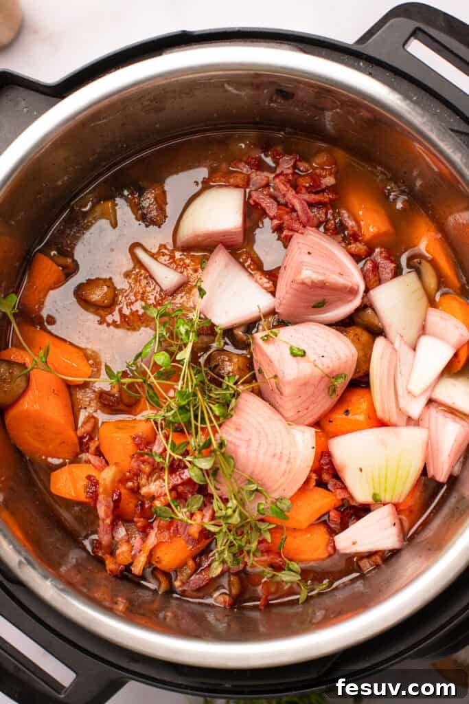 Instant Pot Coq au Vin: Classic French Flavor, Modern Speed 8 Overhead shot of onions, chicken thyme, and carrots in red wine sauce.