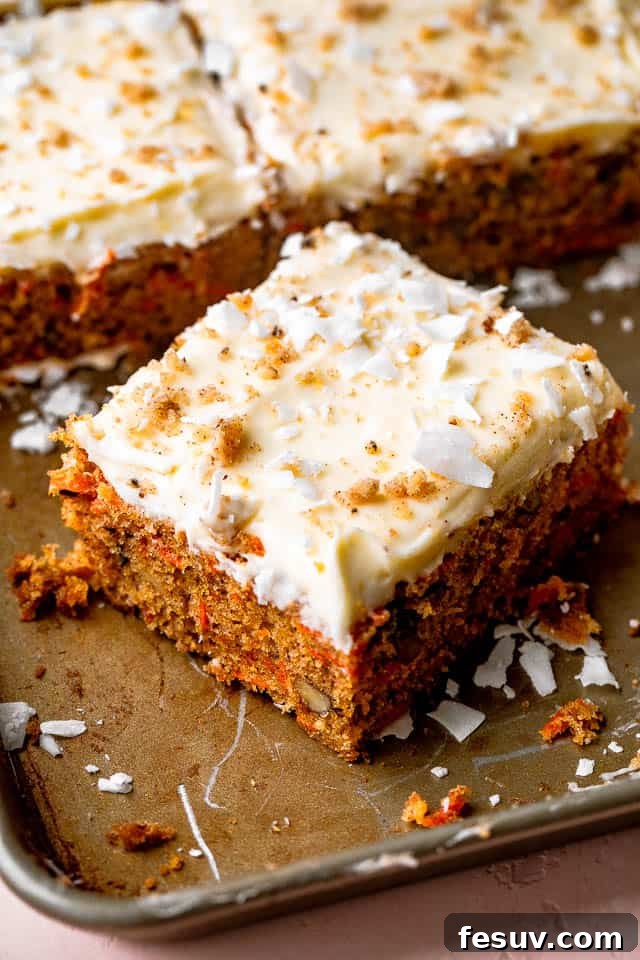 square slice of moist carrot cake with cream cheese frosting, coconut, and walnuts