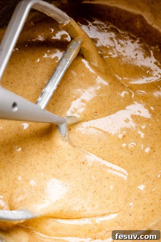Mixing carrot cake batter until smooth and fully combined.