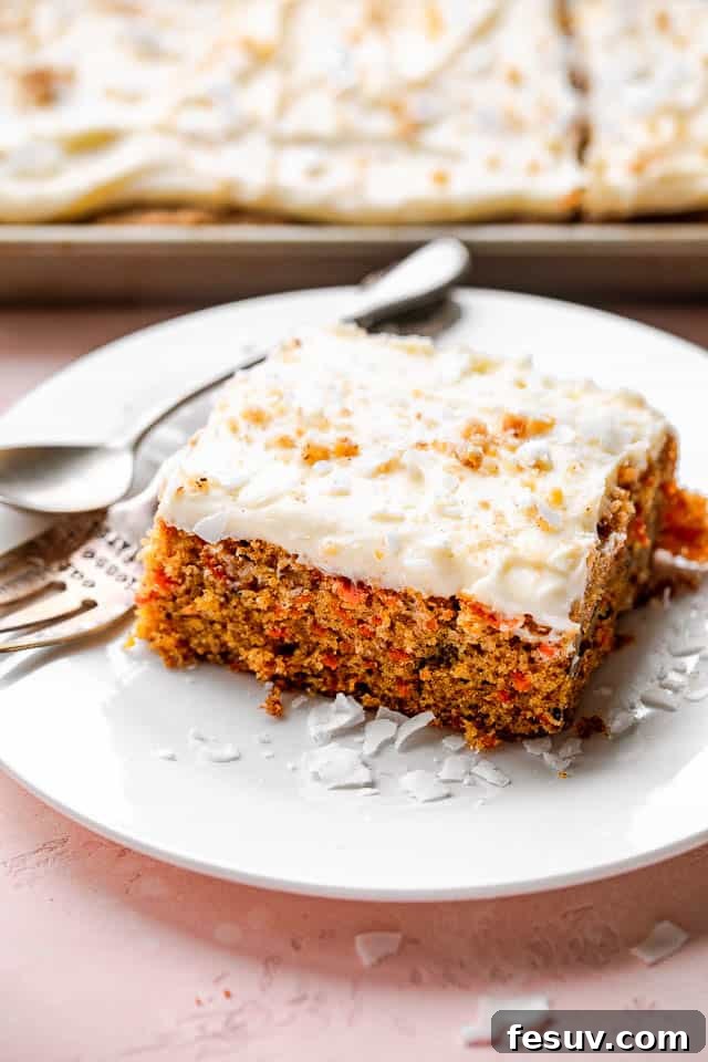 A perfectly portioned slice of carrot cake on a pristine white plate, garnished with a sprinkle of nuts.